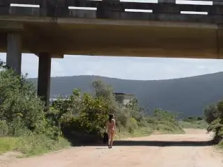 Walking Naked on Open Road under a Bridge