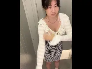 Asian Woman with Big Tits Changing Clothes in the Fitting Room of the Store.