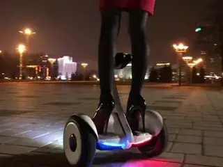 Hot girl driving gyroscooter in high heels and short skirt