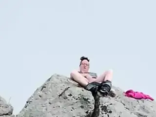 Zoey masturbating in public high up on a rock in the harbor