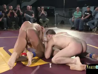 Muscly studs wrestling in front of audience
