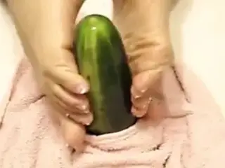 Oiled soles stroking a cucumber