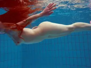 Redhead Simonna showing her body underwater