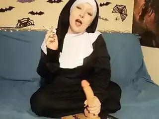 The nun jerks off her dildo while smoking