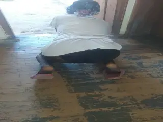 Woman in hijab wipes the floor in the village house