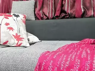 A woman with a good figure lies on the couch and touches herself
