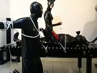 three latex cats tie up their submissive slave