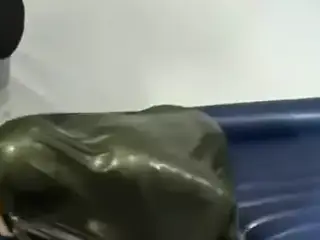 Woman struggling in a green latex bag