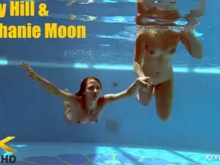 In the indoor pool, two stunning girls swim