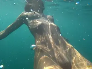 Nude model swims on a public beach in Russia.